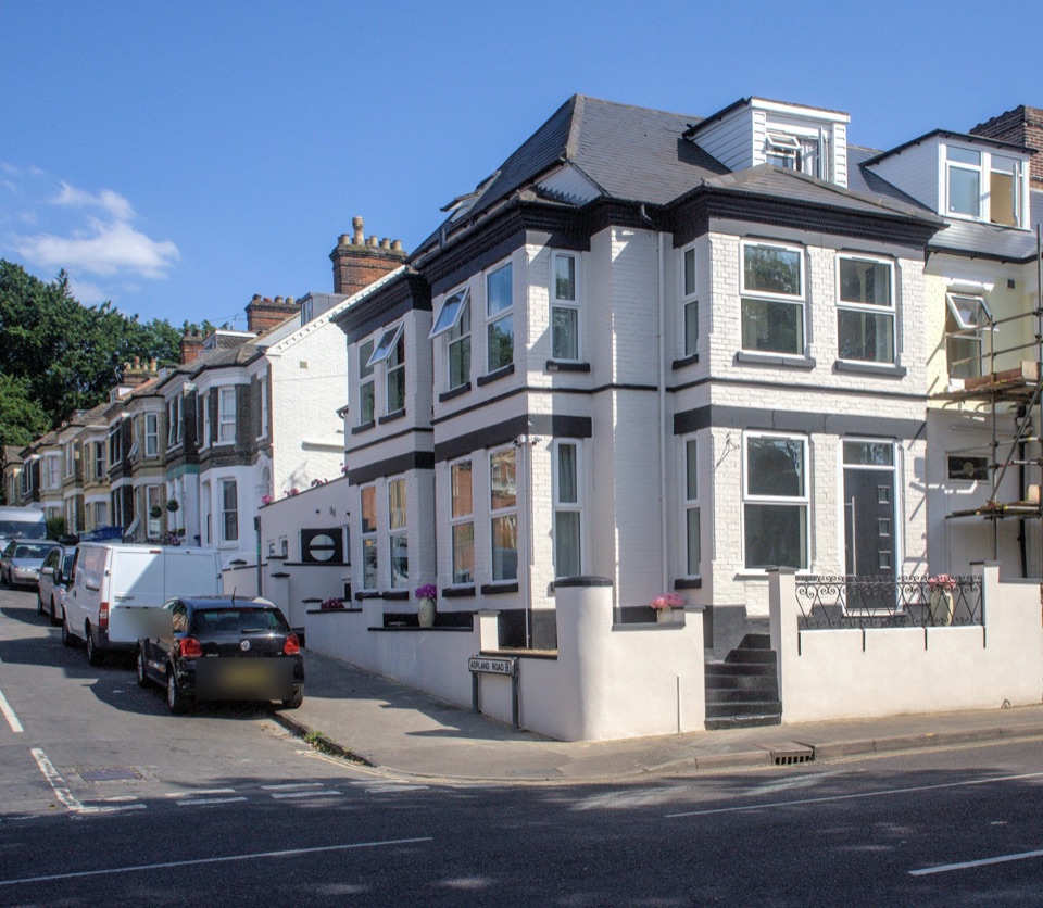 Aspland House, a white-painted corner house with black trim on Aspland Road, Norwich